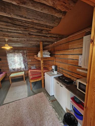 a kitchen in a log cabin with a stove at Hossa Teeriranta in Teeriranta