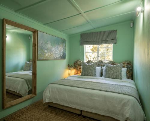 a bedroom with a large bed and a mirror at 19 Mare St Apartments in Howick