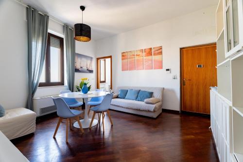a living room with a table and chairs and a couch at Relax in Riva by MONHOLIDAY in Monopoli