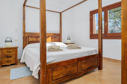 a bedroom with a bed with a wooden frame at Bella Vista su tavolara 5 in Porto San Paolo