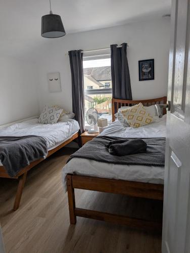 two beds in a room with a window at Spacious 3 bed house near beach! in Lowestoft