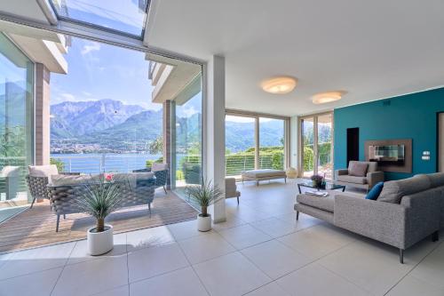 a living room with a view of the mountains at Villa Costanza- private heated pool, steam room & sauna - Bellagio Village Residence in Oliveto Lario