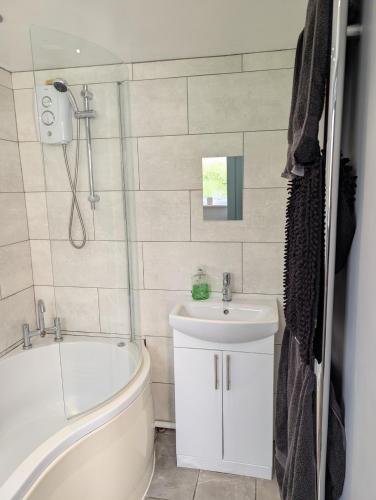 a bathroom with a tub and a sink and a toilet at Spacious 3 bed house near beach! in Lowestoft