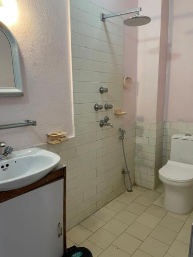a bathroom with a sink and a shower with a toilet at Rato Ghar Hotel and Rooftop Restaurant in Bhaktapur