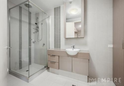 a bathroom with a glass shower and a sink at Parklane Apartments in Fremantle