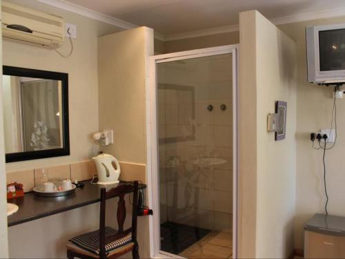 a bathroom with a shower with a glass door at Die Blou Nartjie in Calvinia