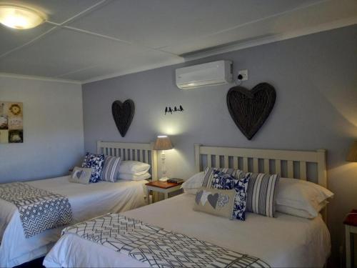 two beds in a room with hearts on the wall at Die Blou Nartjie in Calvinia
