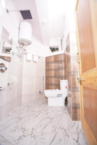 a white bathroom with a toilet and a sink at hotel the kannaz in Srinagar