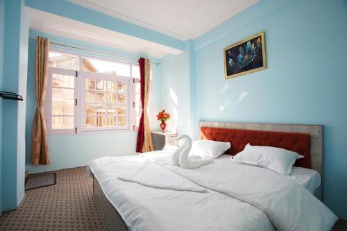 a bedroom with a large bed with a swan on it at hotel the kannaz in Srinagar