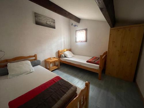 a small bedroom with two beds and a window at L'Ancre Marine in Valras-Plage