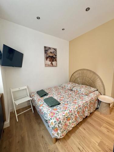 a bedroom with a bed and a chair and a tv at Coudert l Petit studio côté rue l Rez-de-chaussée en Hypercentre & climatisé in Castres