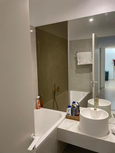 a bathroom with a sink and a bath tub at Suite Luxury Pipera and Spa in Bucharest