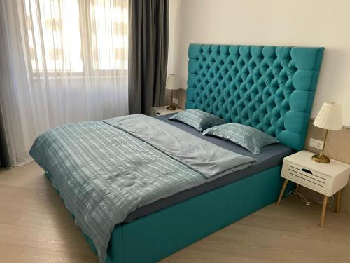 a large bed with a blue headboard in a bedroom at Suite Luxury Pipera and Spa in Bucharest
