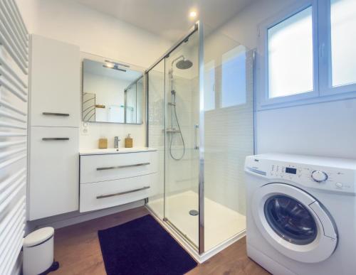 a bathroom with a washing machine and a shower at la Pascaline in Saint-Clément-de-Rivière