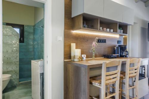 a kitchen with a counter and chairs in a room at Luxury Villa with Private Pool in Skopelos, Nature Retreat, Villa Pine Trees by Kardous in Alikias