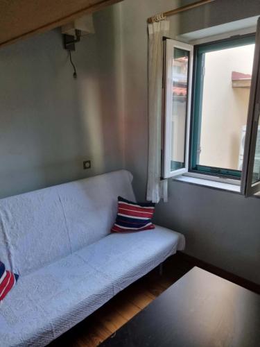 a couch sitting in a room with a window at Οικοδέσπινα in Mytilene