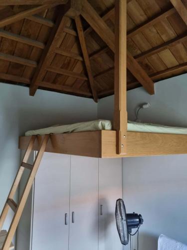 a loft bed in a room with white cabinets at Οικοδέσπινα in Mytilene