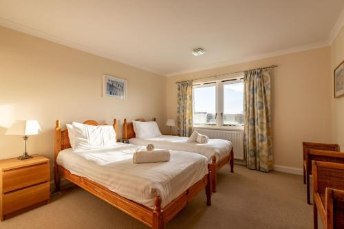 two beds in a room with a window at West Cottage - Elie in Earlsferry