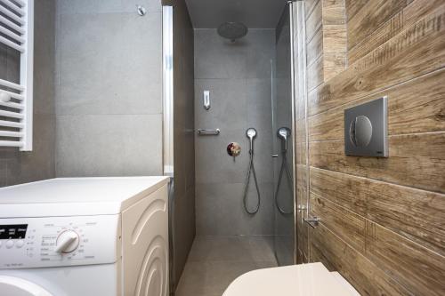 a bathroom with a washing machine and a shower at Athenean Pool Break in Athens