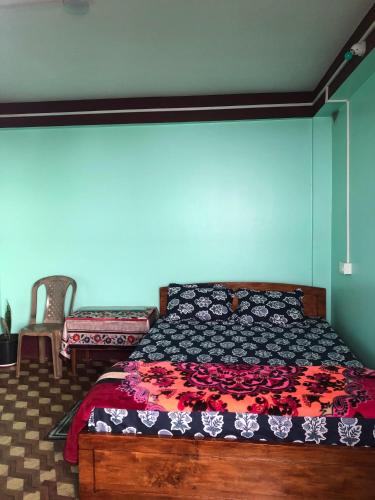 a bedroom with a bed with a black and red comforter at Fable homestay in Pedong