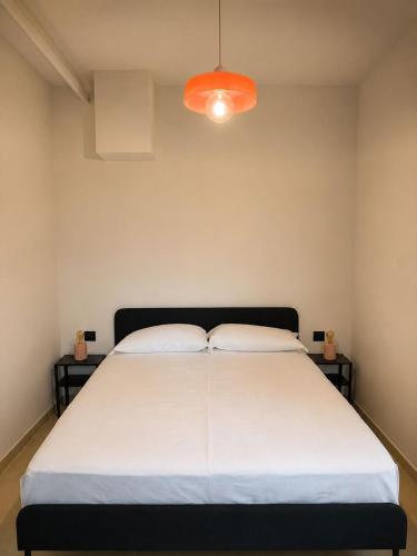 a bedroom with a large white bed with an orange light at Giuditta Room C in Ciriè