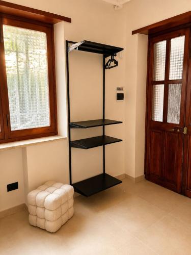 a black shelf in a room with a window at Giuditta Room C in Ciriè