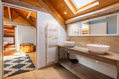 two sinks on a counter in a bathroom with a window at Maison de famille au coeur de son vignoble in Lorignac
