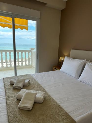 a bedroom with a bed with a view of the ocean at Olympic Beach Rooms in Olympic Beach