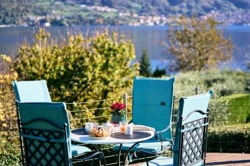 a table and chairs with a table and a view of a lake at Villa Vittoria with private heated pool & shared sauna - Bellagio Village Residence in Oliveto Lario