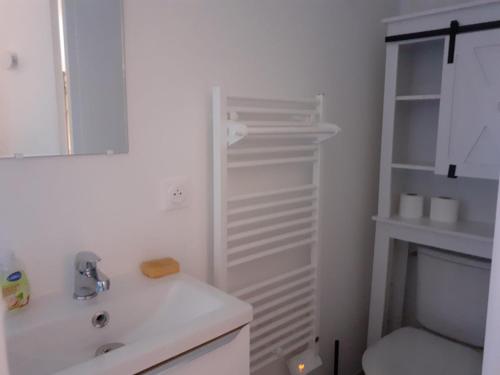 a white bathroom with a sink and a toilet at Les Jasmins in Montaud