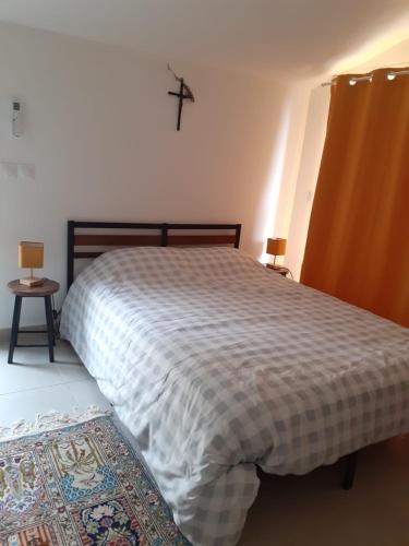 a bedroom with a bed and a cross on the wall at Les Jasmins in Montaud
