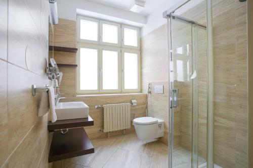 a bathroom with a toilet and a sink and a shower at Ensana Pro Patria in Piešťany