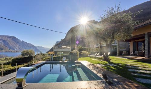 a house with a swimming pool with a view of a mountain at Villa Vittoria with private heated pool & shared sauna - Bellagio Village Residence in Oliveto Lario