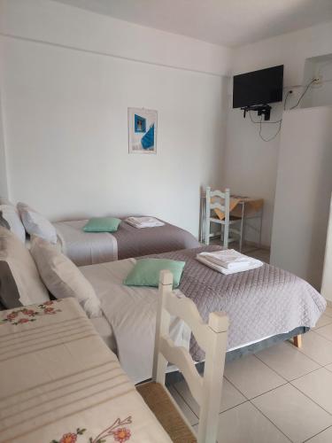 a living room with two beds and a tv at Avra in Alonnisos