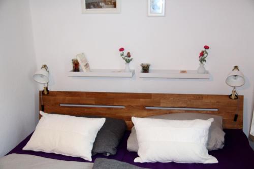 a bedroom with a wooden headboard and two white pillows at Villa am Oberpfuhl in Lychen