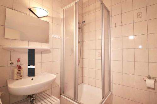 a white bathroom with a sink and a shower at Villa am Oberpfuhl in Lychen
