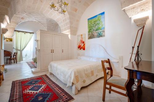 a bedroom with a bed and a desk and a piano at Villa Tonia in Fasano