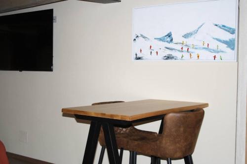 a wooden table with a chair and a television on a wall at La Breila Morgex in Morgex