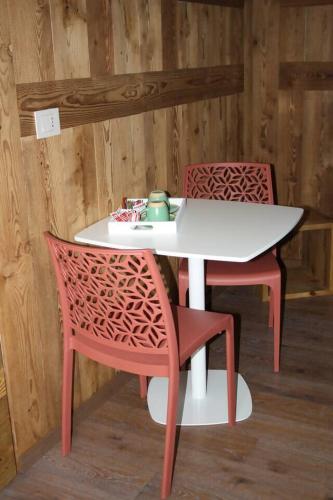 ein Tisch und zwei Stühle mit einem weißen Tisch und einem Tisch und Stühlen in der Unterkunft La Brenva Morgex in Morgex