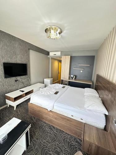 a bedroom with a large bed and a flat screen tv at Carmen Suite in Esenyurt