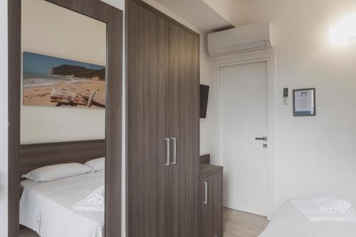 a bedroom with a wooden door leading to a bed at Il mare di Giulio in Marcelli