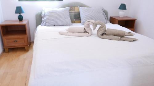 a bedroom with a white bed with towels on it at Hillside Apartments in Révfülöp