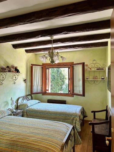 a bedroom with two beds and a window at Ibón de la Sierra in El Pueyo de Jaca