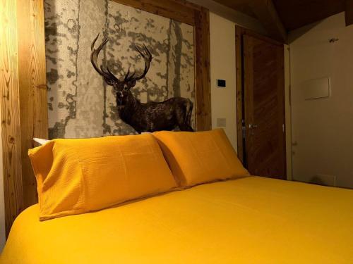 a bedroom with a bed with a deer on the wall at La Becca Morgex in Morgex