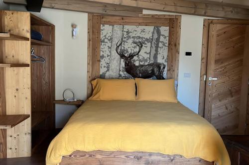 a bedroom with a bed with a deer on the wall at La Becca Morgex in Morgex