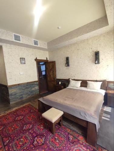 a bedroom with a large bed and a rug at Senger Qala Riverside in Qax