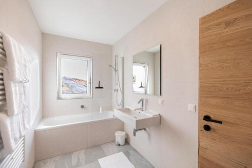 a white bathroom with a sink and a bath tub at Radstädter Hütte am Rossbrand in Radstadt