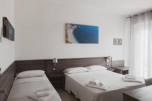 a bedroom with two beds with towels on them at Il mare di Giulio in Marcelli