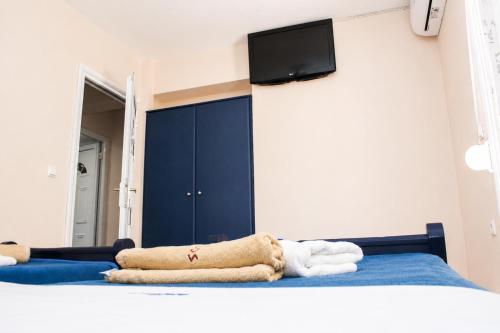 a bedroom with a bed with a tv on the wall at Hotel Dionysos Polichrono in Polychrono