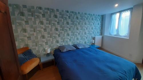 a bedroom with a blue bed and a window at Entre Golf et Mer RDC in Dieppe